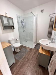 a bathroom with a shower and a toilet and a sink at *BRAND NEW* Luxury Country Lodge in Burnham on Crouch