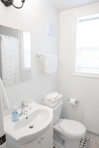 Baño blanco con aseo y lavamanos en 2Bdrm Victorian Style Tiny Home - long stays U7 en Burlington