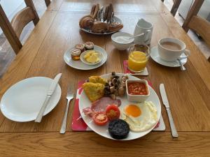 a plate of breakfast food on a wooden table at Wellington view One en suite shower and super king bed in Wellington