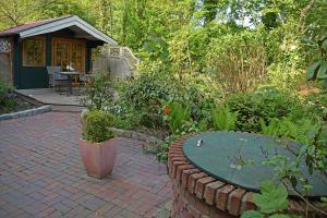 a patio with a table in a garden at das Fischerhus in Bensersiel