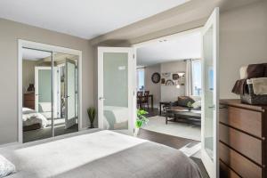 a bedroom with a bed and a living room at Superb 2 bedroom downtown with river view in Saskatoon