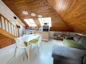 a kitchen and living room with a table and a couch at sarl location Elodie et Ioannis in La Léchère