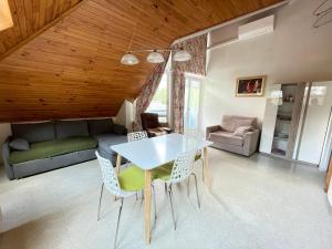 a living room with a table and chairs and a couch at sarl location Elodie et Ioannis in La Léchère