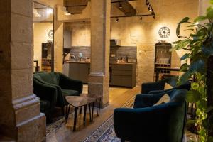 a lobby with green chairs and a table and a counter at Babel Suites in Valletta