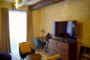 a living room with a television and a table and chairs at Babel Suites in Valletta