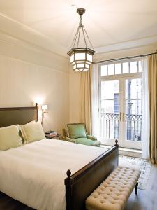 Un dormitorio con una cama grande y una ventana en The Greenwich Hotel, en Nueva York