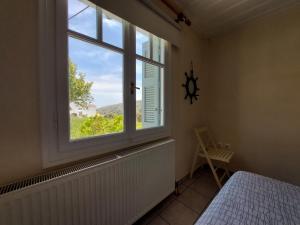 sypialnia z oknem z łóżkiem i widokiem w obiekcie Palaiokrassa sunny appartment w mieście Andros