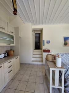 kuchnia z białymi szafkami i podłogą wyłożoną kafelkami w obiekcie Palaiokrassa sunny appartment w mieście Andros +29 zdjęć