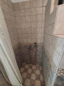 W łazience z podłogą wyłożoną kafelkami znajduje się prysznic. w obiekcie Palaiokrassa sunny appartment w mieście Andros