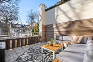 eine Terrasse mit einem Sofa und einem Tisch in der Unterkunft APARTVIEW Apartments Krefeld - WLAN - Zentral - ruhig in Krefeld