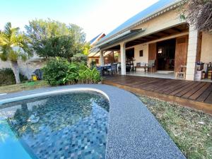 una piscina davanti a una casa di Très belle villa,piscine chauffée, jacuzzi,hammam. a Étang-Salé les Bains