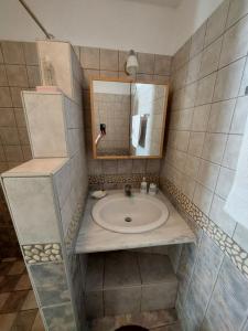 łazienka z umywalką i lustrem w obiekcie Palaiokrassa sunny appartment w mieście Andros