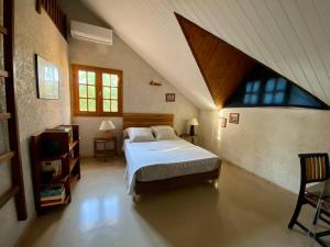 - une chambre mansardée avec un grand lit dans l'établissement Très belle villa,piscine chauffée, jacuzzi,hammam., à Étang-Salé les Bains