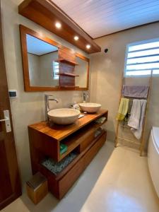 un bagno con due lavandini e uno specchio di Très belle villa,piscine chauffée, jacuzzi,hammam. a Étang-Salé les Bains