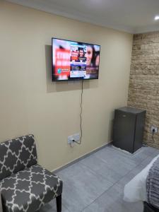 a room with a flat screen tv on the wall at MIRAJO Guest House in Cape Town