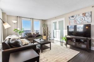 a living room with a couch and a flat screen tv at Superb 2 bedroom downtown with river view in Saskatoon