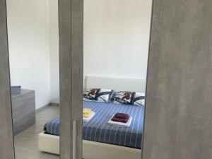 a bedroom with a bed with blue sheets and a mirror at Roberta House Rozzano 2 in Rozzano