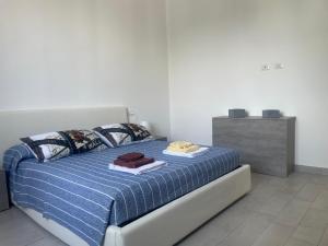 a bedroom with a bed with a blue comforter at Roberta House Rozzano 2 in Rozzano