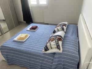 a bed with blue sheets and pillows on it at Roberta House Rozzano 2 in Rozzano