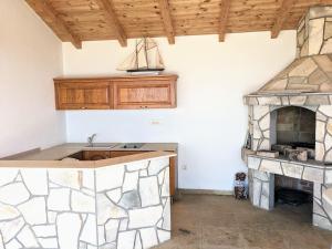 a kitchen with a stone fireplace and a stove at Serene Sea View Apartments in Utjeha in Utjeha