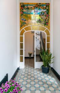 un couloir orné d'une peinture murale et de fleurs dans l'établissement Ambiorix Residence, à Bruxelles