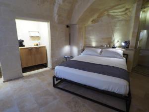 1 dormitorio con 1 cama grande en una habitación en Dimore dei Mercanti, en Matera