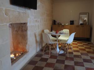 ein Esszimmer mit einem Tisch, Stühlen und einem Kamin in der Unterkunft Dimore dei Mercanti in Matera