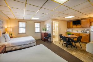 ein Hotelzimmer mit einem Bett und einem Tisch sowie einer Küche in der Unterkunft Tahiti Inn in Ocean City
