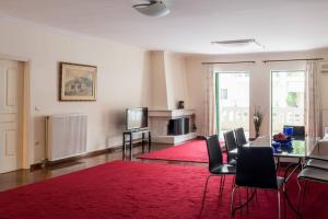 uma sala de estar com uma mesa e um tapete vermelho em Spacious 3bedroom Apartment Nafplion em Nafplio