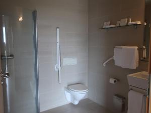 a white bathroom with a shower and a toilet at Hotel Laki in Kirkjubæjarklaustur