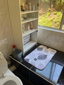 een badkamer met een toilet en een handdoek op de vloer bij RaHa Soul Sanctuary - Entire Home in De Deur