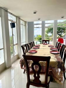 a dining room with a table and chairs and windows at RaHa Soul Sanctuary - Entire Home in De Deur