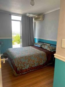 een slaapkamer met een bed in een kamer met een raam bij RaHa Soul Sanctuary - Entire Home in De Deur