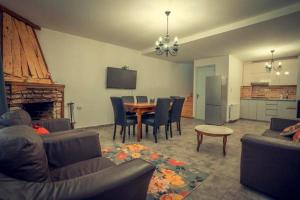 a living room with a table and chairs and a kitchen at Cottage Panorama in Bakuriani