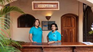 Duas mulheres de camisa azul em frente a um balcão. em Boutique Hotel Secret Garden Granada em Granada