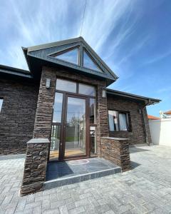 a brick house with a large glass door at BLACK SEA HOUSE in Vama Veche