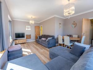 a living room with two blue couches and a table at Beach Haven - Uk42241 in Littlestone-on-Sea