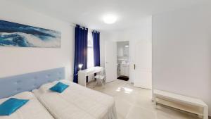 a white bedroom with a bed and a desk at Villa las Buganvillas MASPALOMAS - Cocina y habitaciones con baños privados in Maspalomas