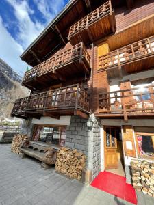 a building with wooden balconies and a pile of logs at B&B Gressoney in Gressoney-la-Trinité