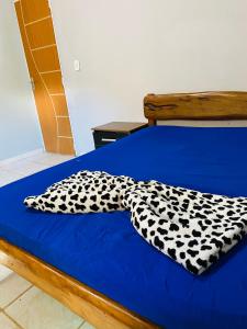 a blue bed with a black and white blanket on it at Casa Borboleta na Vila de São Jorge in Alto Paraíso de Goiás