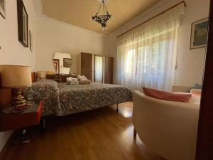 a bedroom with a bed and a couch and a chair at Villetta la Fortezza in Radicofani
