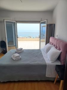 a bedroom with a large bed with a large window at Stargaze Apartment with Sea View in Zakynthos Town