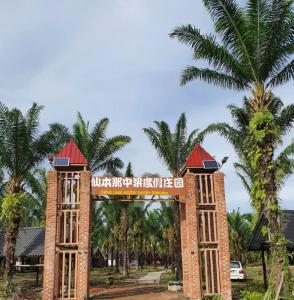 a gate at the entrance to a resort with palm trees at 仙本那中梁度假庄园 ZhongLiang Holiday Garden Semporna in Semporna
