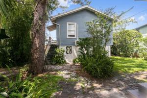 a blue house with a tree in the yard at That 70’s Themed Apt Close to Coffee, Food + Shops in Tampa