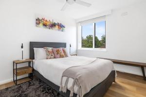 una camera da letto bianca con un letto grande e una finestra di South Yarra apartment with stunning views a Melbourne