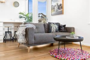 een woonkamer met een bank en een tafel bij South Yarra apartment with stunning views in Melbourne