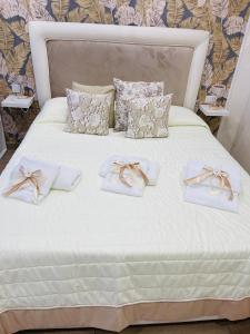 a white bed with white towels and bows on it at La Dimora Dei Sogni in Naples