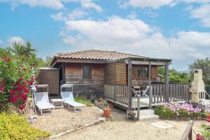 a small wooden cabin with two chairs and a gazebo at Petite Maison En Bois Exotique in Figari +13 photos