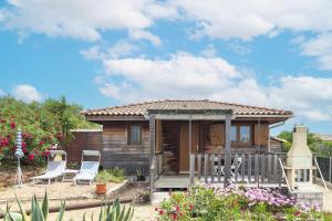 een klein houten huis met stoelen en bloemen bij Petite Maison En Bois Exotique in Figari