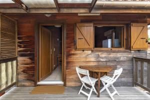 een houten huis met een tafel en twee stoelen op een veranda bij Petite Maison En Bois Exotique in Figari